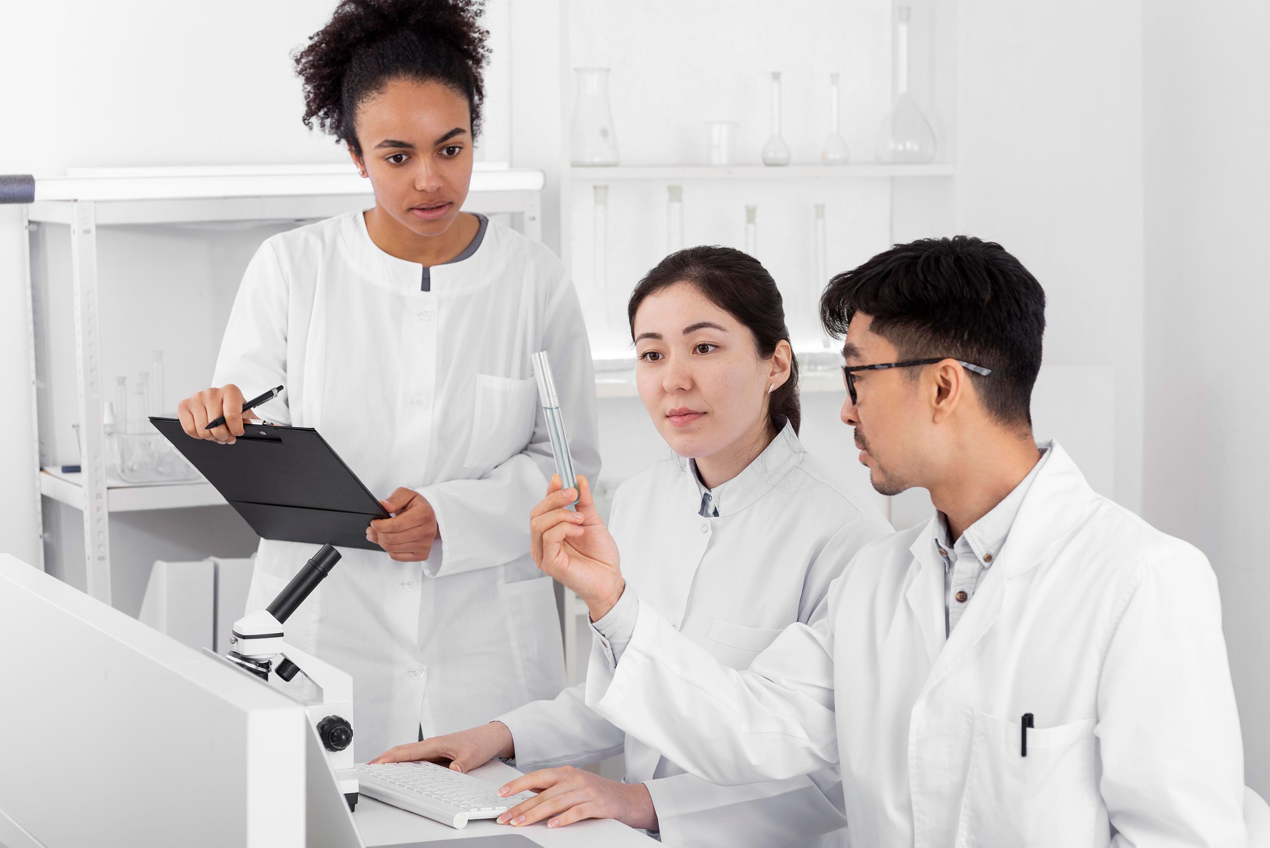 Chercheurs en laboratoire discutant autour d’un échantillon, symbole des avancées en biotechnologie